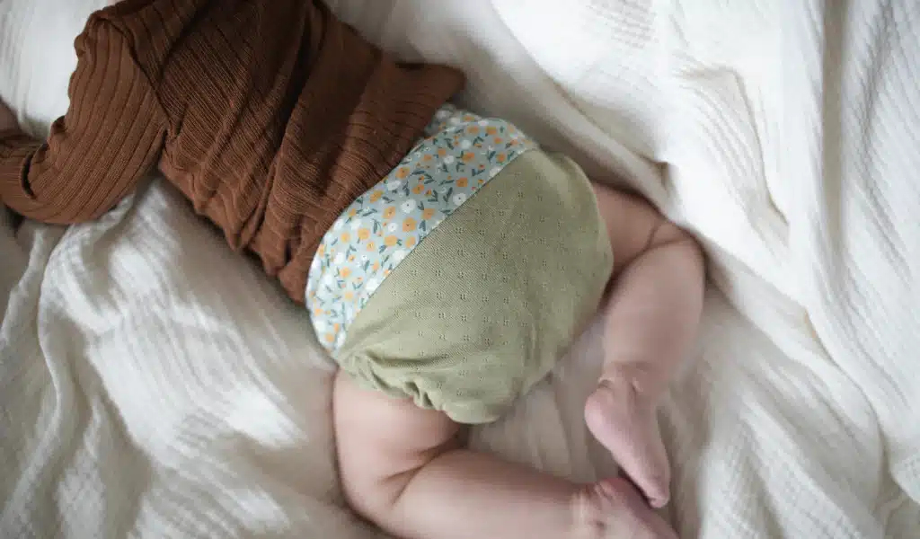 A baby's body photographed from behind with a cloth diaper on.