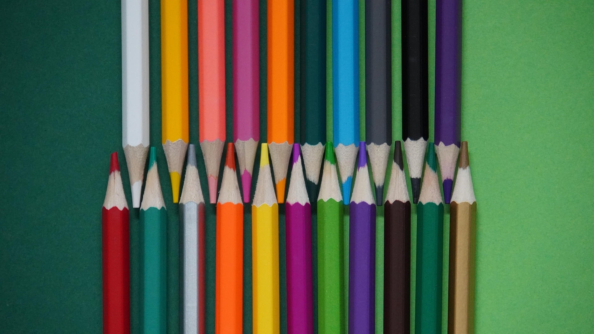 Colored pencils in different colors lie on a plain background