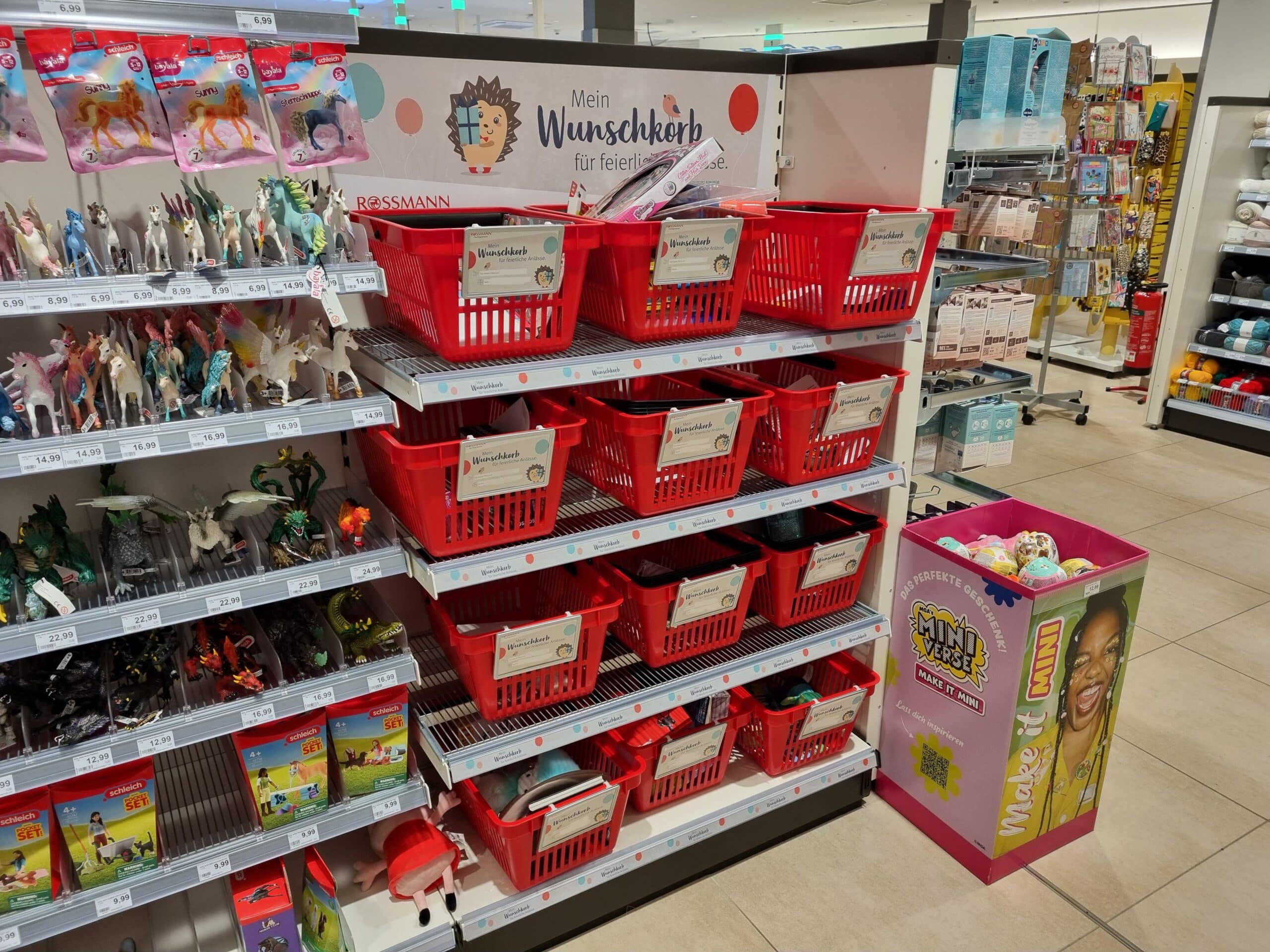 Several wish boxes that have already been filled by children in a Rossmann store.