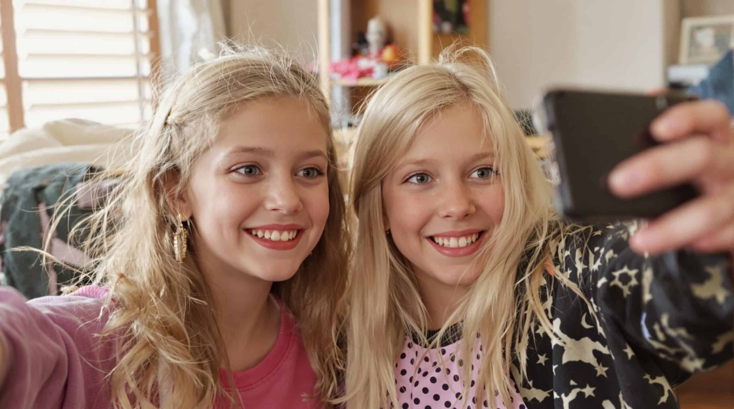 Two girls take a selfie with their smartphone