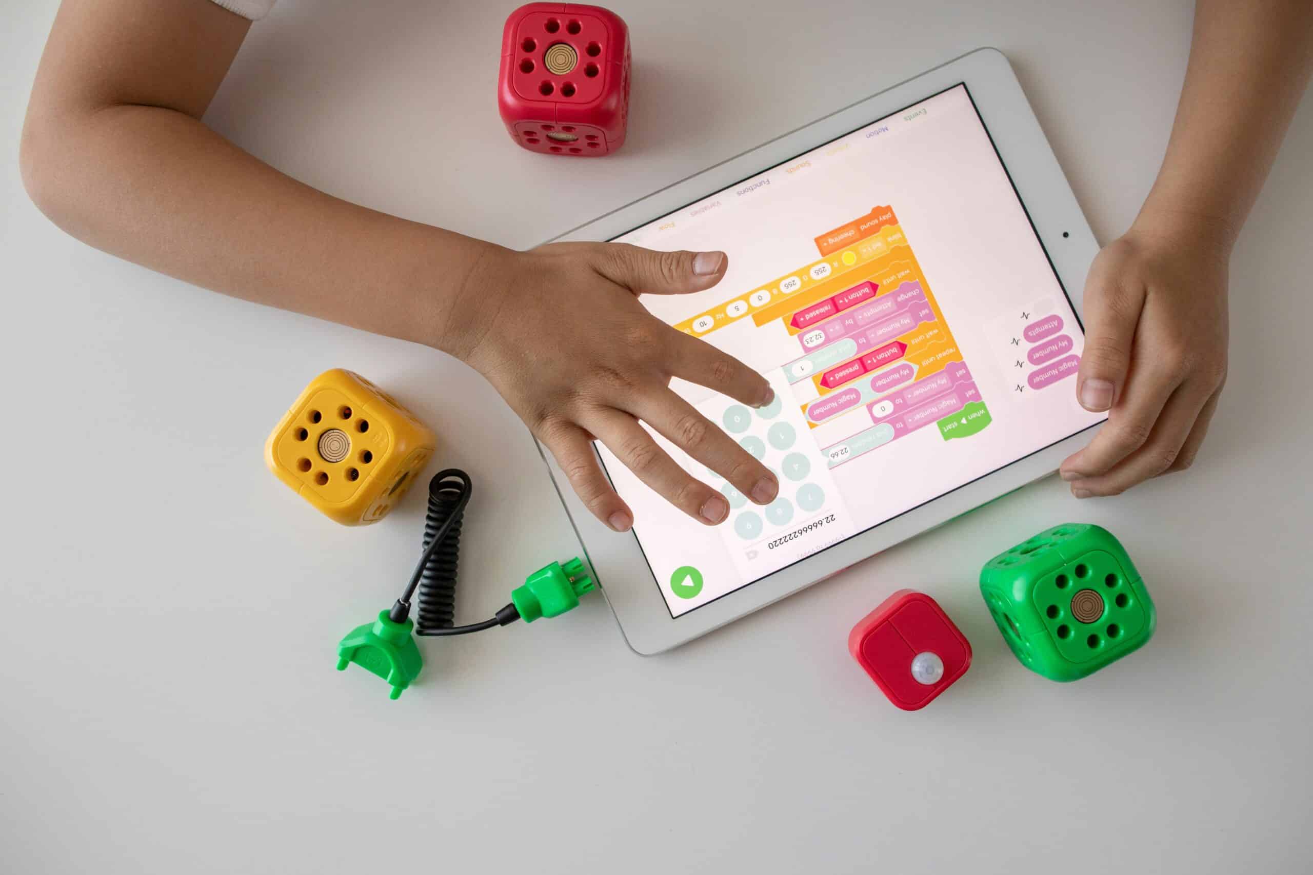 A child programs on a tablet with a child-friendly app.